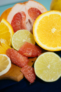 柑橘 橘子 柠檬 酸橙 葡萄柚，柚老式板 柠檬水和玻璃绿松石背景上一杯果汁