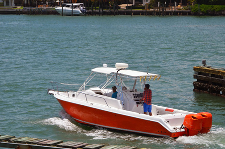 明亮的橙色和白色运动渔船巡航向坎湾在佛罗里达州沿海航道附近迈阿密海滩