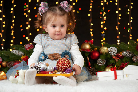 儿童女孩肖像中的圣诞装饰，快乐的情绪，冬天假日概念，深色背景照明和博克灯火