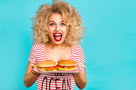 演播室时尚肖像一个美丽的滑稽女孩在绿松石背景, 金发女郎拿着一个