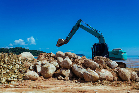 一个大的挖掘机和石头一起工作。巨大的蓝的挖掘机挖