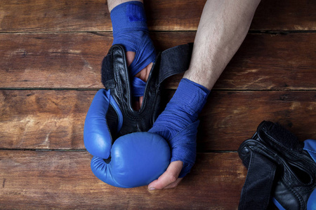 男子的手, 而穿拳击手套在一个木制的背景.拳击训练或格斗训练的概念.