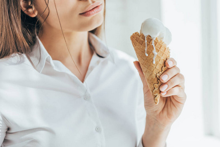 妇女抱着冰淇凌在锥体的裁剪视图