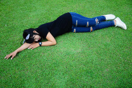 在花园的草地上睡觉是疲惫的女孩