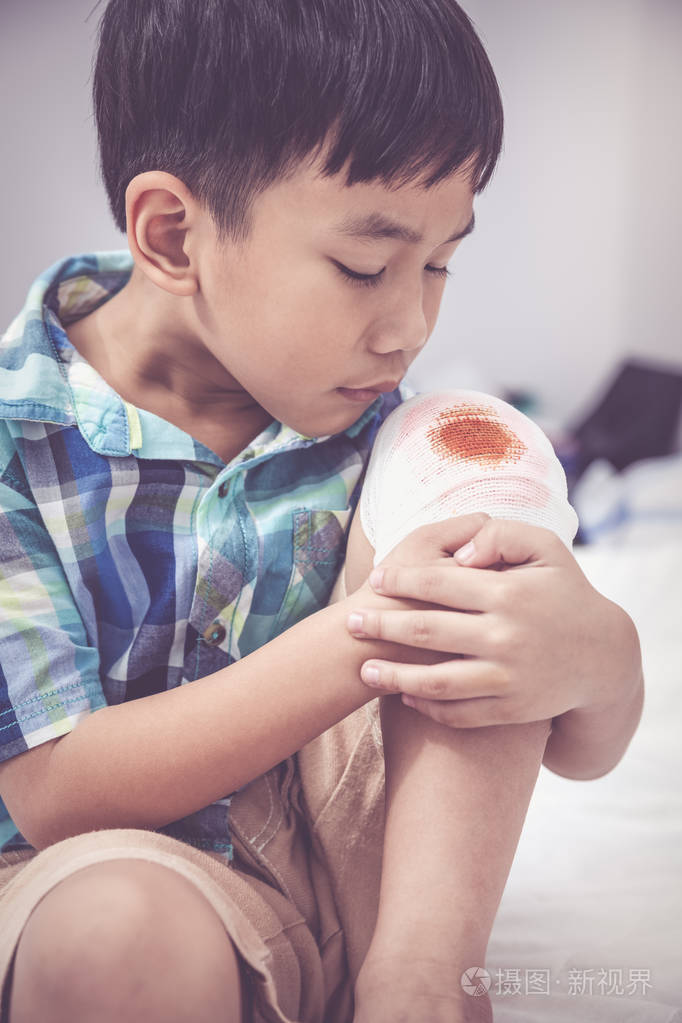 伤口用绷带包扎着孩子的膝盖.复古色调