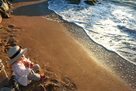 孩子在大海和天空背景下的海滩上放松。暑假和旅行概念