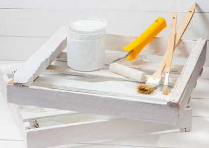 刷子和滚子用白漆画木板