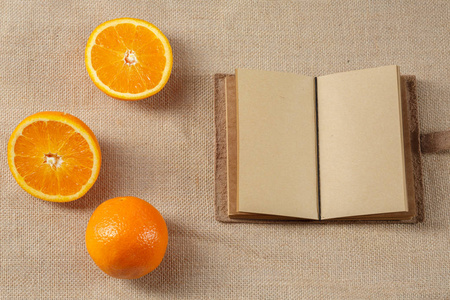橙色和躺在麻布面上的打开笔记本
