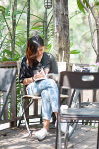 年轻女子亚洲放松与阅读本书和相机的电影，在咖啡馆 户外生活方式与复古色调图片