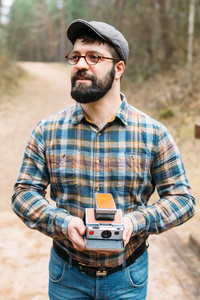 具髯毛具电影 photocamera 在森林里的年轻人