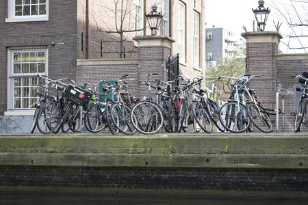 旧自行车成一排，在一家银行的一名在阿姆斯特丹运河