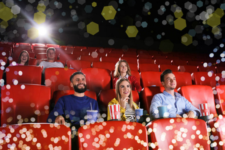 在电影院看电影的年轻人.模糊灯光框架照片