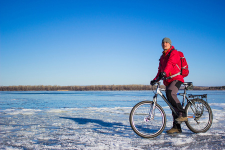 在冰冻的河面上自行车上的旅程图片