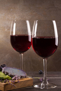 眼镜和瓶的红葡萄酒，葡萄 熏衣草和香蒜酱奶酪在案板上。葡萄酒与食物的静物