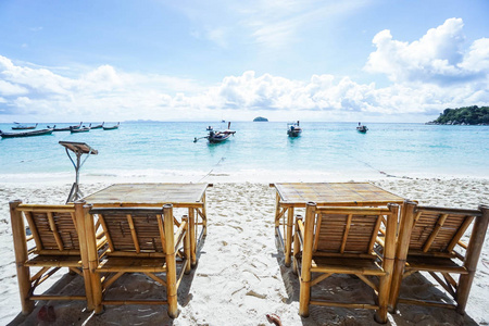 椅子和桌子上海滩的海和长尾船背景