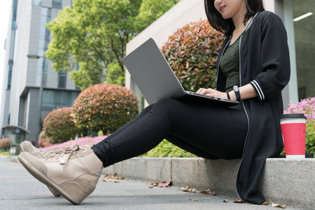 一个漂亮的学生女人正在使用便携式计算机
