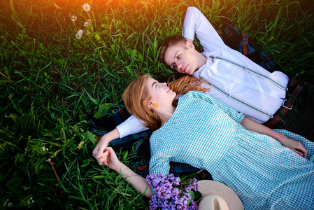 年轻夫妇躺在草地上，放松，从上面查看