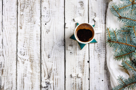 一杯热咖啡与糖和肉桂在老木桌与云杉的分支。顶部视图平面放置组对象