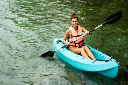 快乐年轻美丽的女子皮划艇在湖上