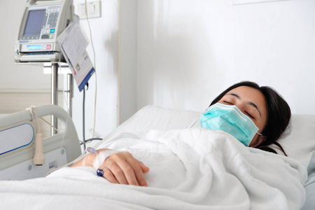 关闭年轻妇女病人躺在医院的床上, 静脉正常生理盐水照片