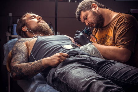 纹身师在纹身沙龙工作.专业纹身显示纹身店制作纹身的过程
