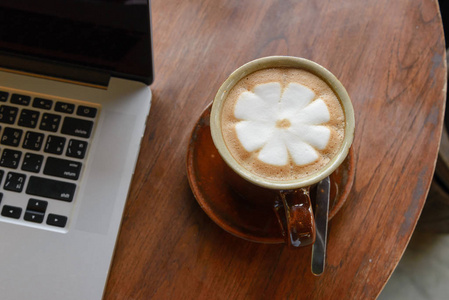 咖啡杯和内咖啡厅的木桌上的笔记本电脑。c 事业