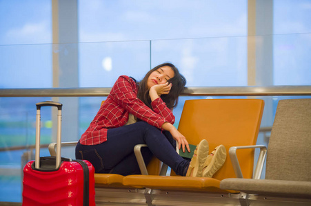 年轻的疲惫和疲惫的生活在机场的亚洲韩国旅游妇女的生活方式肖像睡觉无聊坐在登机门大厅等待延误或取消航班