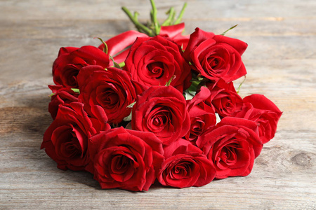 美丽的红玫瑰花在木质背景上