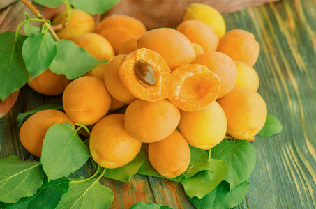 杏在木头上。成熟的杏在木质背景。木桌特写上有叶子的有机杏
