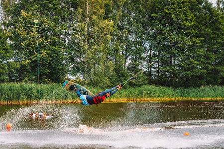 Marupe, 拉脱维亚。2018年7月20日。年轻人滑水在湖上, 做雷利, frontroll, 跳踢球和滑块。滑水