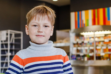 一个可爱的小男孩在明亮的咖啡馆的肖像, 看着相机