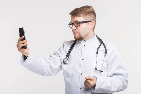 年轻男性医生在他的手机上拍照片