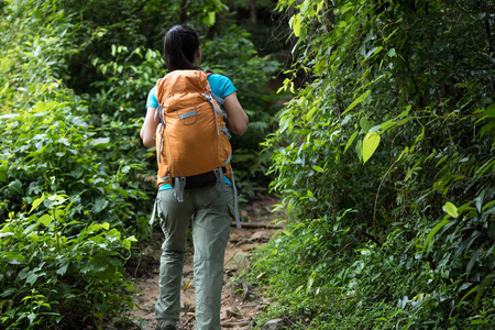 妇女徒步旅行与背包在森林小径