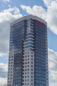 在蔚蓝的天空背景下的蓝色和白色的现代石座公寓大楼