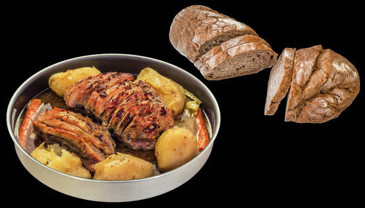全土豆烤猪肉火腿片烤箱和全谷物国产乡村的褐色面包切面包孤立的黑色背景