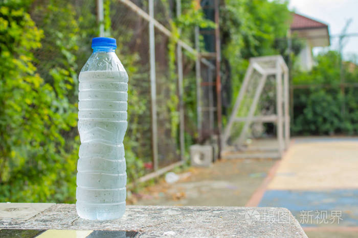桌上的瓶子里放着冰冷的饮用水.在足球场上