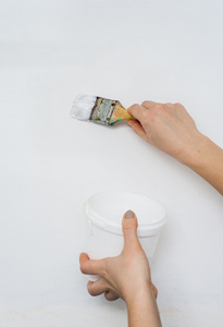 油漆罐和刷子在女性手中