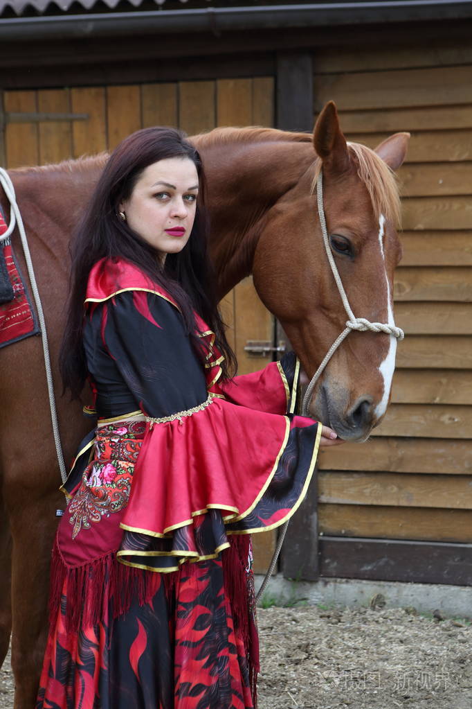 美丽的吉普赛人穿着鲜艳的衣服坐在一匹马上