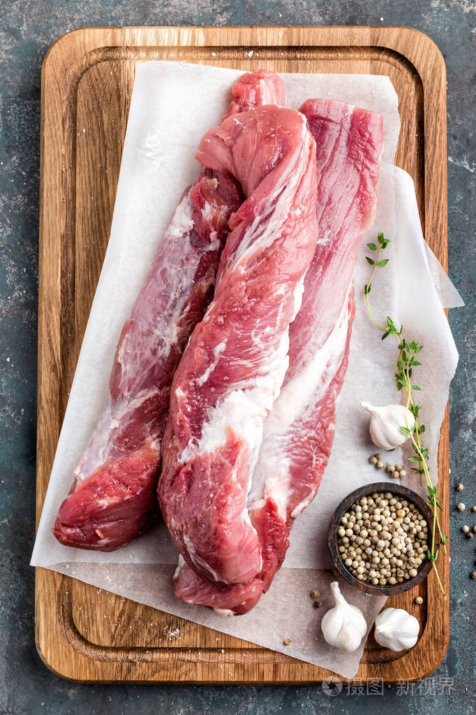 新鲜的生猪肉里脊木菜板上深色背景上
