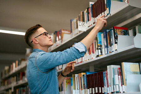 在书店找书的人。图书馆的学生试图在书架上找到课本。高分辨率