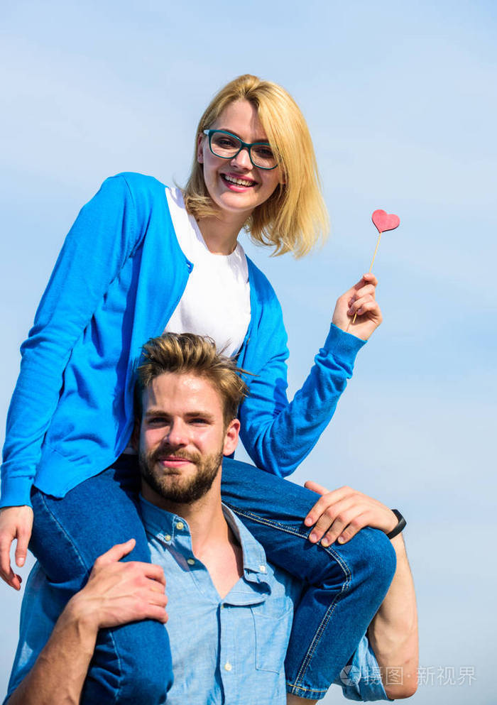 男人扛着女朋友的肩膀, 天空的背景.夫妻俩快乐的日子一起玩.