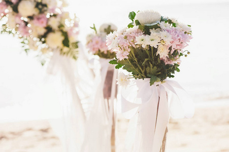 老式的玫瑰花束安排婚礼装饰与海面背景