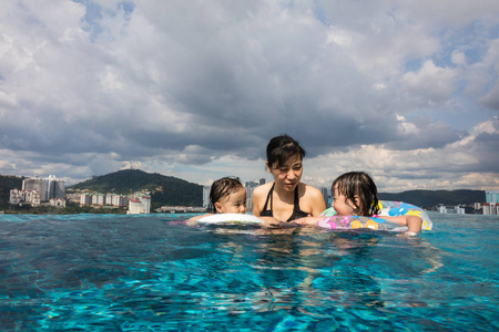 亚洲的中国家庭，在室外的游泳池里玩