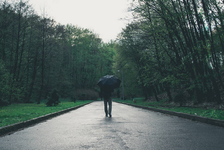 男人在雨天走过公园