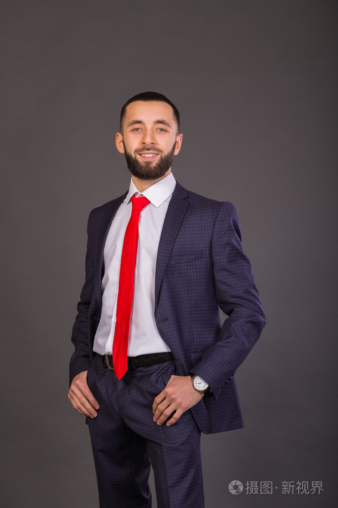 年轻的商人.一个穿着一套漂亮的西装,白衬衫,红领带