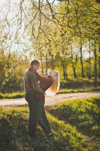 恋人拥抱在树林中的夕阳的光芒照片