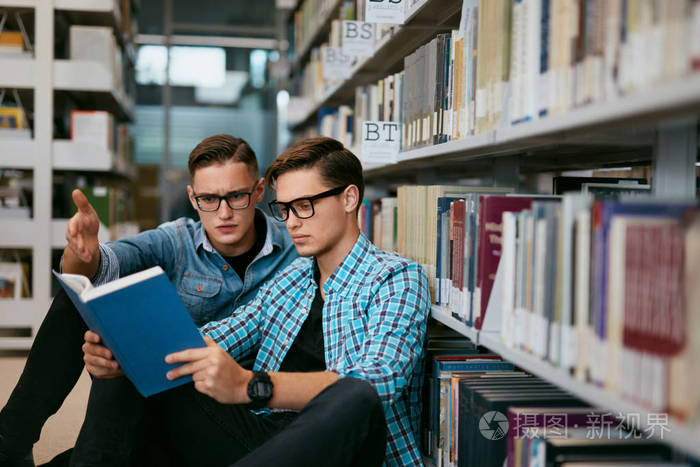 大学图书馆的男子从教科书中学习.高分辨率