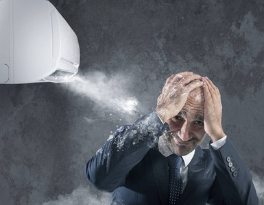 商人试图保护自己冰冷的冷气机照片