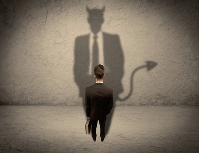 推销自己面对他自己的恶魔影子的推销员照片