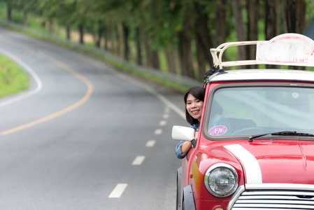 女人在挥舞着窗口笑脸而出的汽车公路旅行